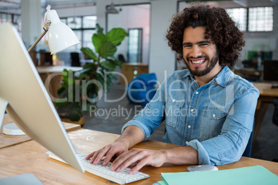 Cheerful male graphic designer working at desk