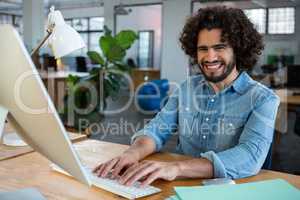 Cheerful male graphic designer working at desk