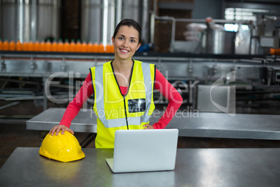 Portrait of factory worker standing in drinks production factory