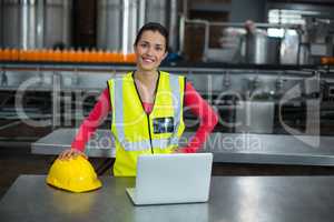 Portrait of factory worker standing in drinks production factory