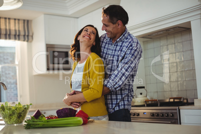 Couple embracing each other in kitchen