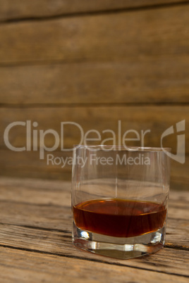 Glass of whisky on wooden table