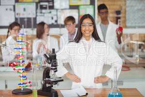 Portrait of school girl standing with hand on hip in laboratory