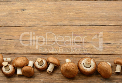 Champignon mushrooms on old wooden table. Top view.