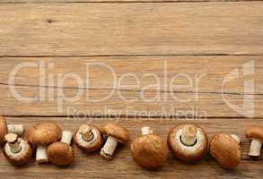 Champignon mushrooms on old wooden table. Top view.