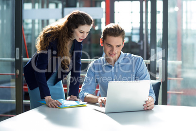 Businesspeople having discussion over laptop