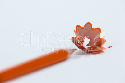 Close-up of orange colored pencil with shavings