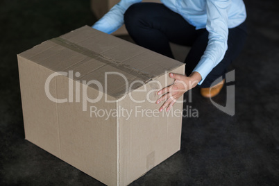 Female factory worker picking up cardboard boxes