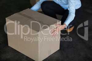 Female factory worker picking up cardboard boxes