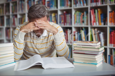 Tensed school teacher studying in library