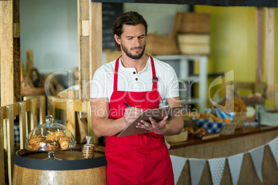 Bakery staff writing on clipboard at counter