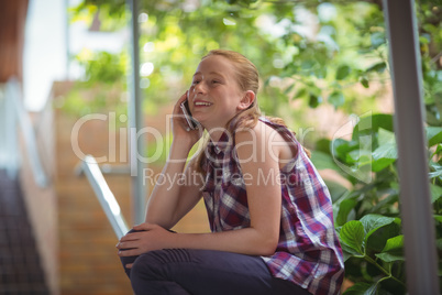 Happy schoolgirl talking on mobile phone