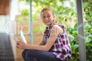 Portrait of happy schoolgirl holding mobile phone