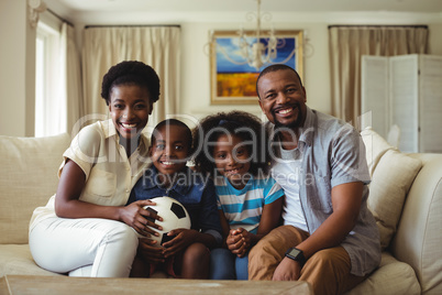 Portrait of parents and kids watching television in living room