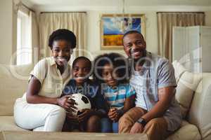 Portrait of parents and kids watching television in living room