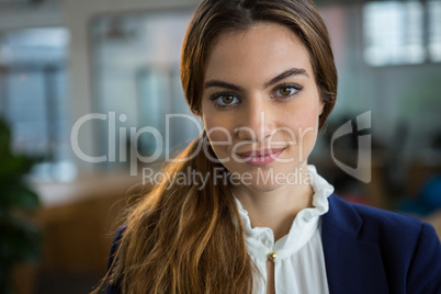 Confident female executive standing in creative office