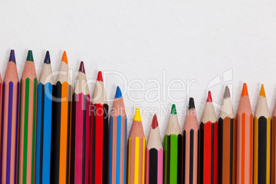 Close-up of colored pencils arranged in a wave pattern