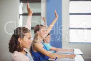 Student raising hand in classroom