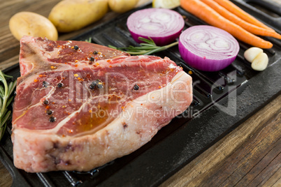 Sirloin chop and ingredients in black box against wooden background