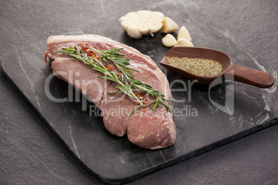 Sirloin chop, garlic and spices on black slate plate