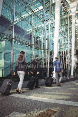 Business executives walking with suitcase outside platform