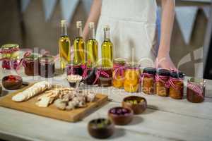 Olive oil, jam, pickle placed together on table