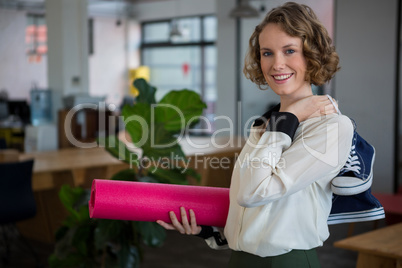 Female graphic designer with sneakers and yoga mat