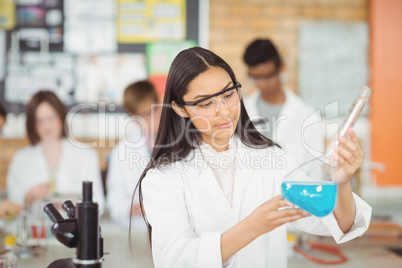 Attentive schoolgirl doing a chemical experiment in laboratory