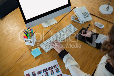 Graphic designer using graphic tablet and desktop