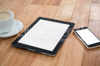 Cup of coffee with digital table and mobile phone