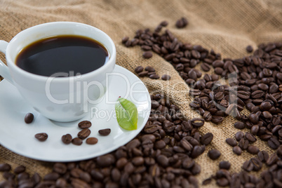 Black coffee, coffee beans and leaf on sack