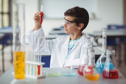 Attentive schoolboy doing a chemical experiment in laboratory