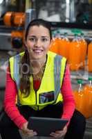 Female factory worker holding digital tablet