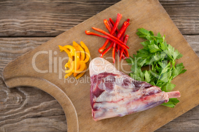 Rib chop, bell pepper and corainder leaves on wooden tray against wooden background