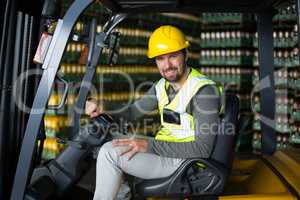 Portrait of factory workers sitting in forklift