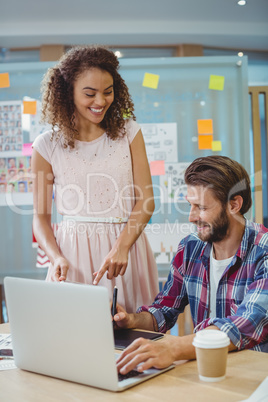 Graphic designers interacting while using laptop and graphic tablet