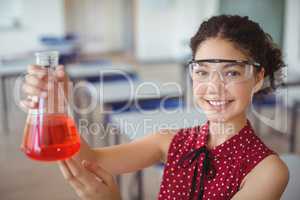 Portrait of smiling schoolgirl doing a chemical experiment in laboratory