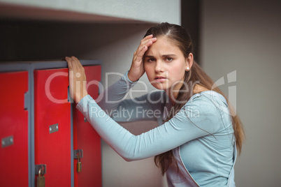 Portrait of sad schoolgirl standing in locker room