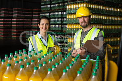 Two factory workers monitoring cold drink bottles