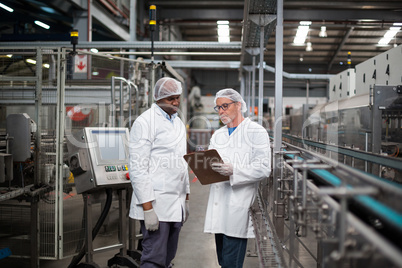 Two factory engineers discussing with each other