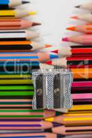 Colored pencils and sharpener on white background