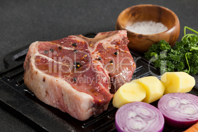 Sirloin chop and ingredients on black grill