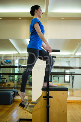 Determined woman exercising on wunda chair