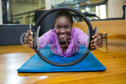 Portrait of fit woman exercising with pilates ring in fitness studio