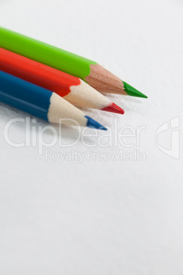 Three colored pencils on white background