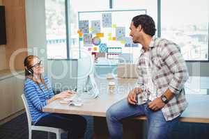 Graphic designers interacting with each other in conference room