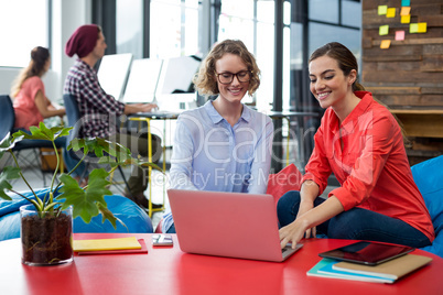 Business executives discussing over laptop