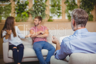 Couple arguing in counselling session with a doctor