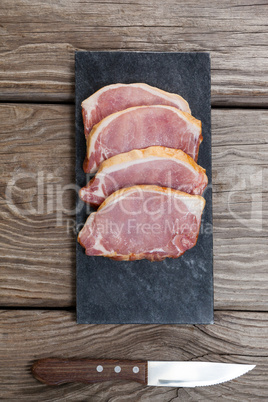 Sirloin chop on black slate plate with knife