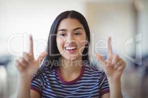 Portrait of happy schoolgirl gesturing in classroom